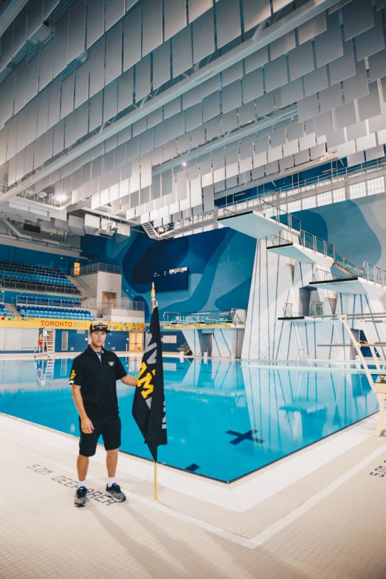 Greg Danko with Invictus Flag inside the Aquatic Centre at the Toronto Pan Am Sports Centre (TPASC).