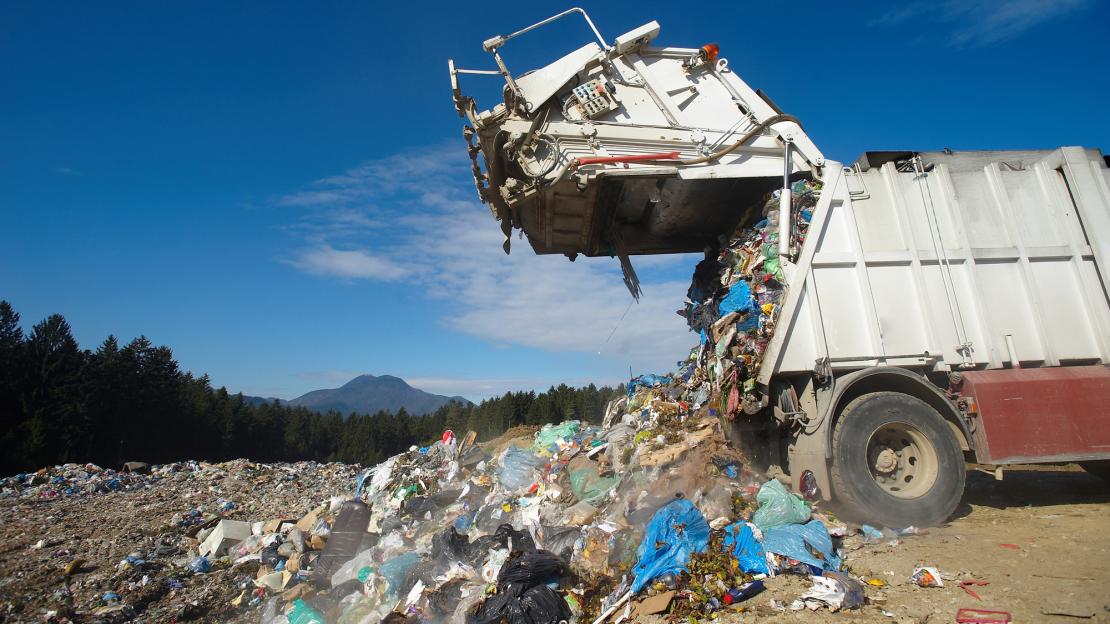 Garbage truck dumping waste into landfill 