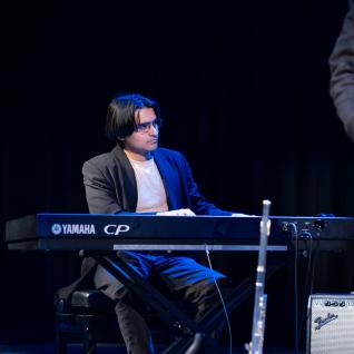 One student playing the piano in the group "VxD"