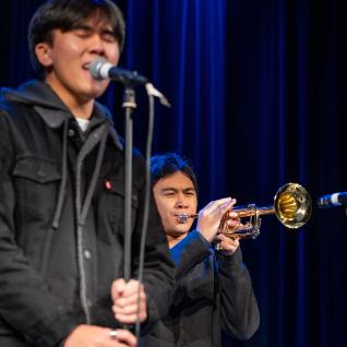 One student playing the trumpet as the vocalist sing in the group "VxD"