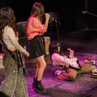 The guitarist went all the way on the ground while playing the guitar in the student group "Jr Princess"