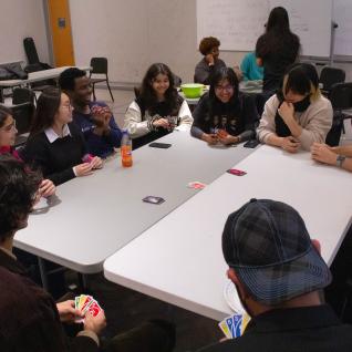 A big table of eleven students playing uno