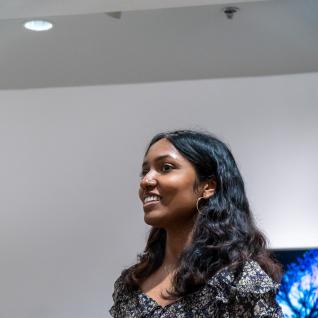 Graduating student, Myuri Srikugan, smiling as she presents at the artist talk.
