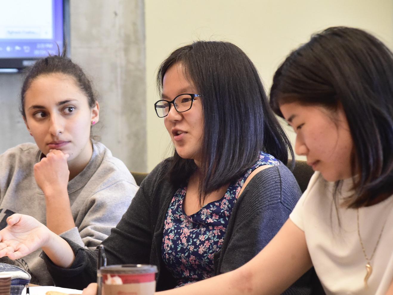 Three students in discussion in a classroom at UTSC
