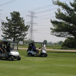 two teams in golf carts making their way to the courses