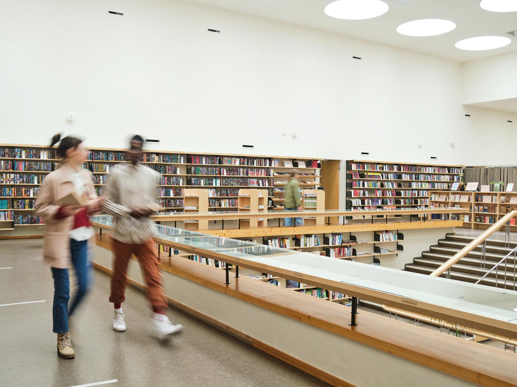 Two students walking in a library