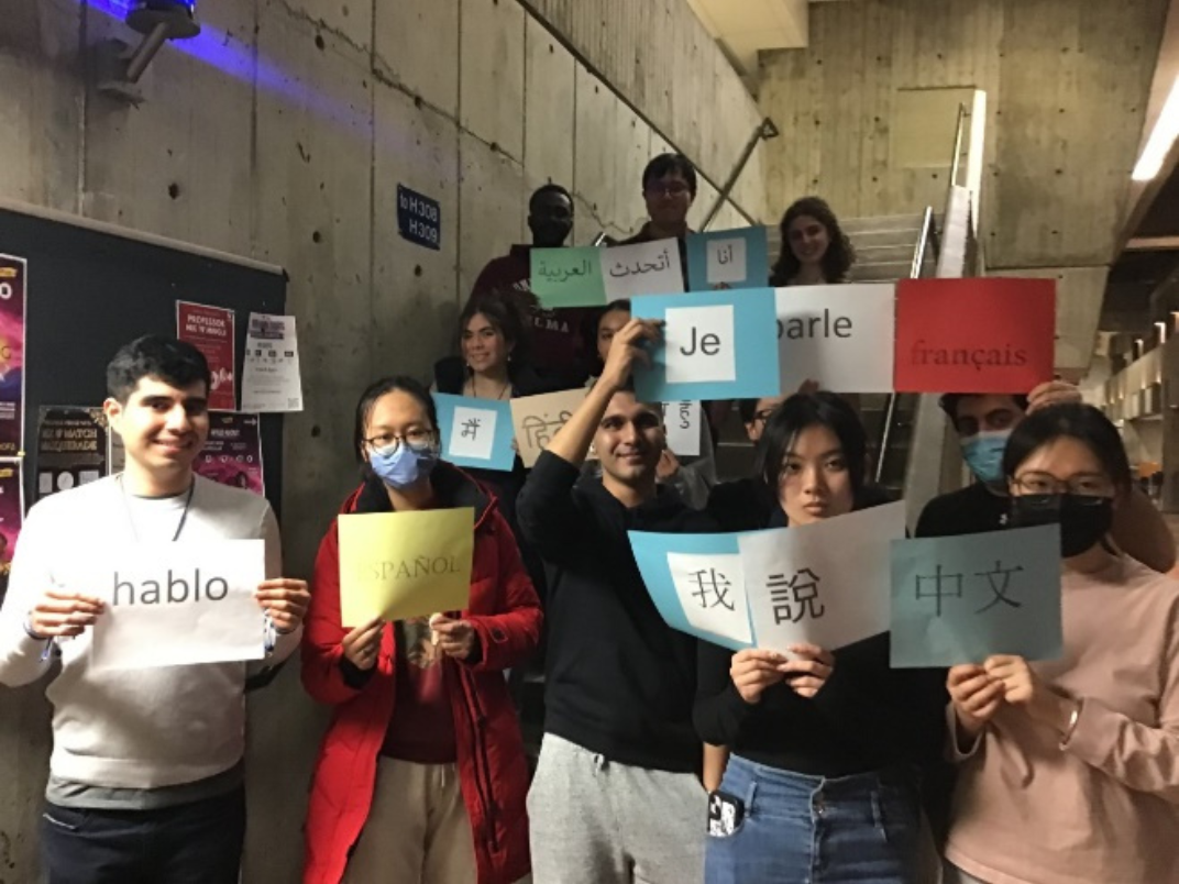 Students hold signs written in various languages