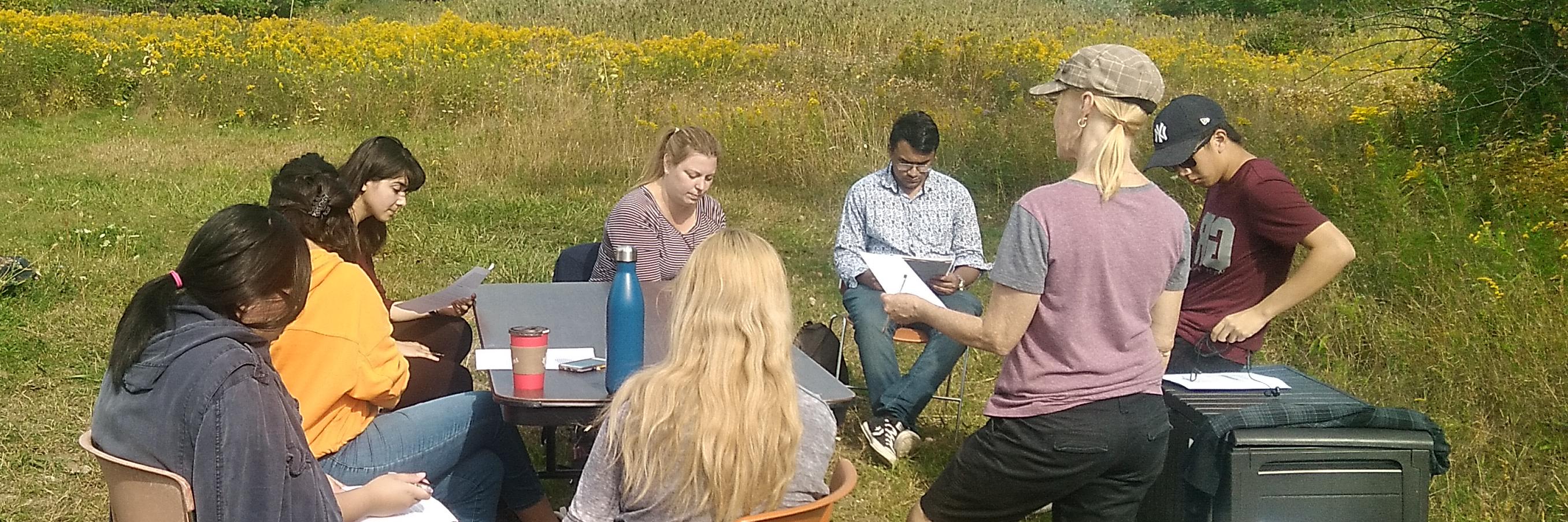 people discussing findings at campus farm 