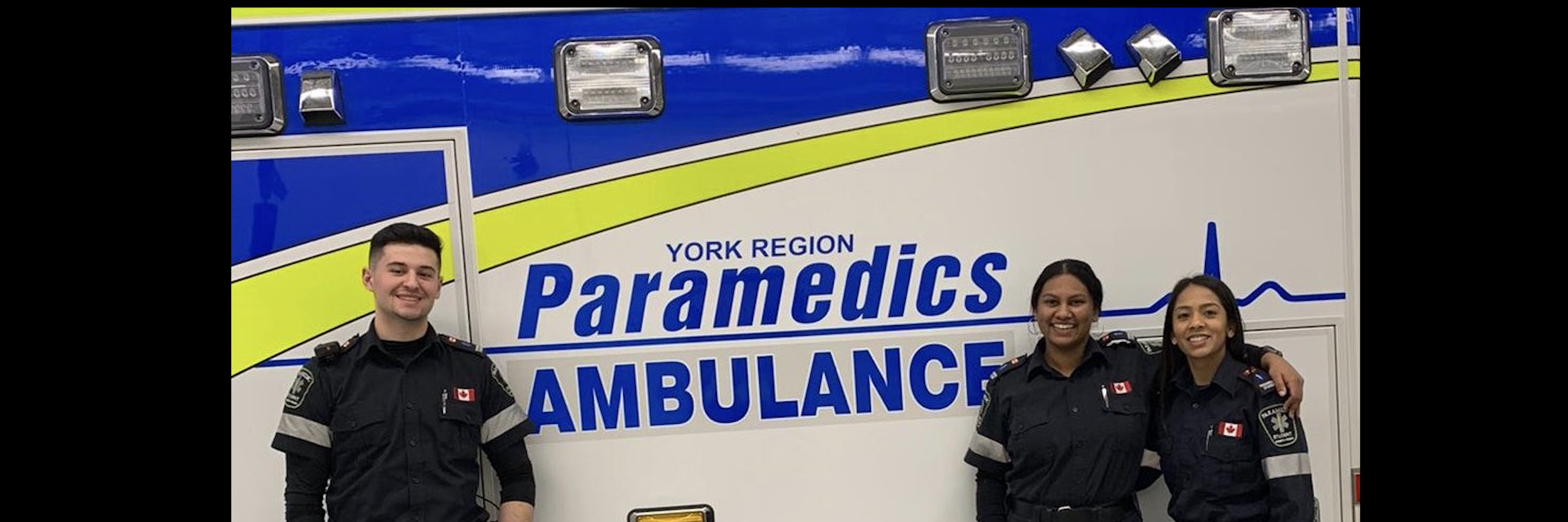 three students standing in front of Paramedic Ambulance 
