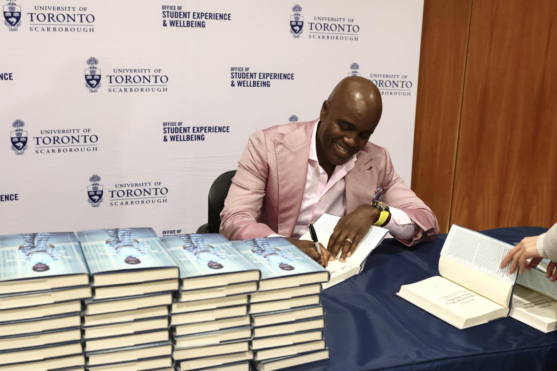 Hall signs copies of his memoir, No Bootstraps When You’re Barefoot: My rise from a Jamaican plantation shack to the boardroom of Bay Street, for participants at the Nov. 23 event.  