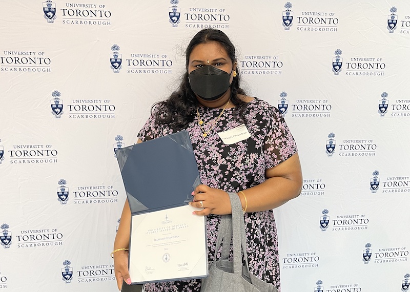 Ilakkiah Chandran holding her University of Toronto student leadership award. 
