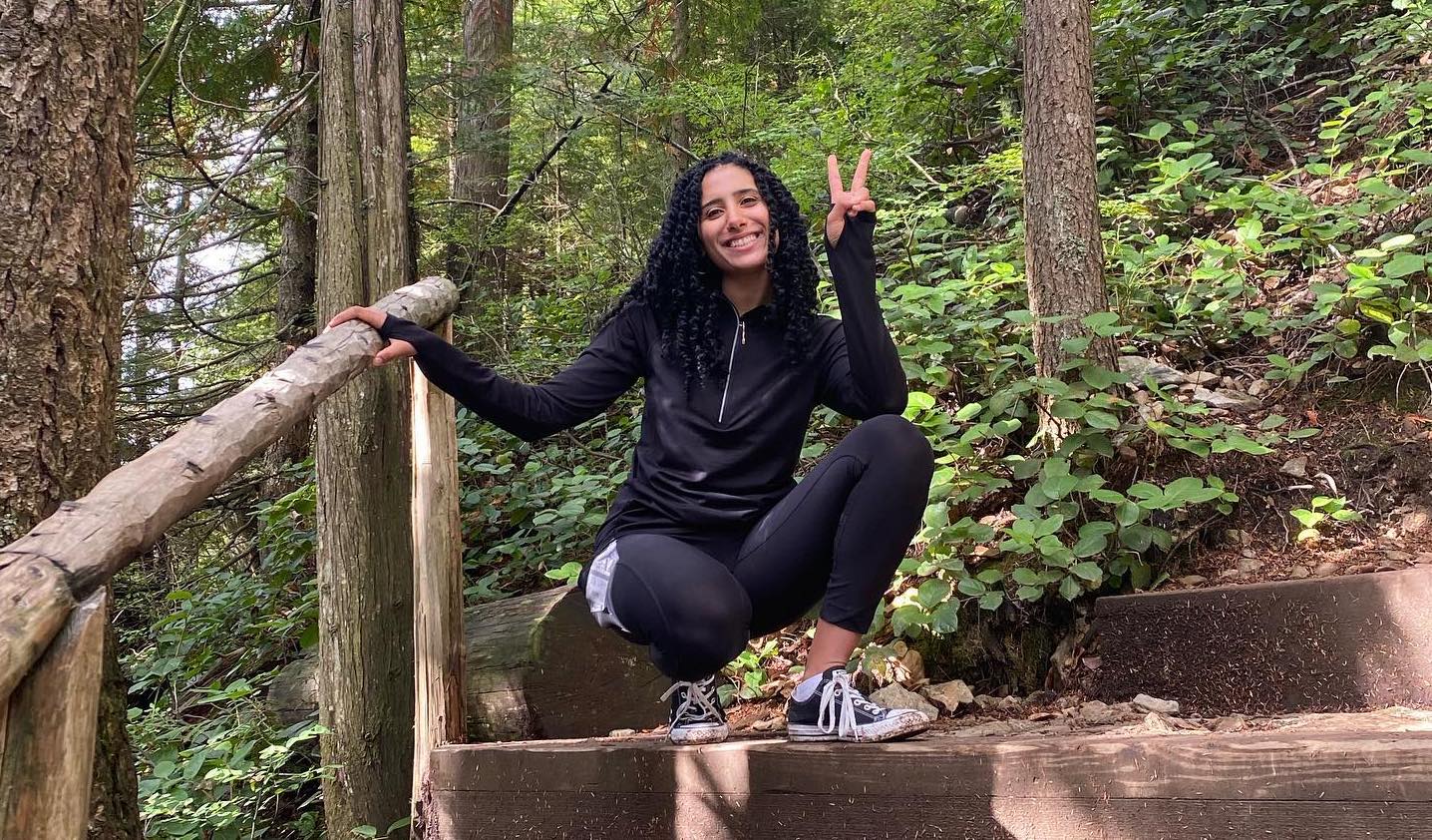 A photo of alum Iman Mounib in a forest