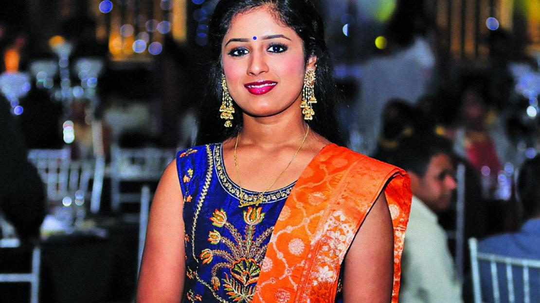portrait of tamil woman in traditional attire, a royal blue dress with a bright orange sash over her shoulder