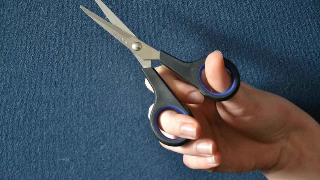 Hand holding a scissor