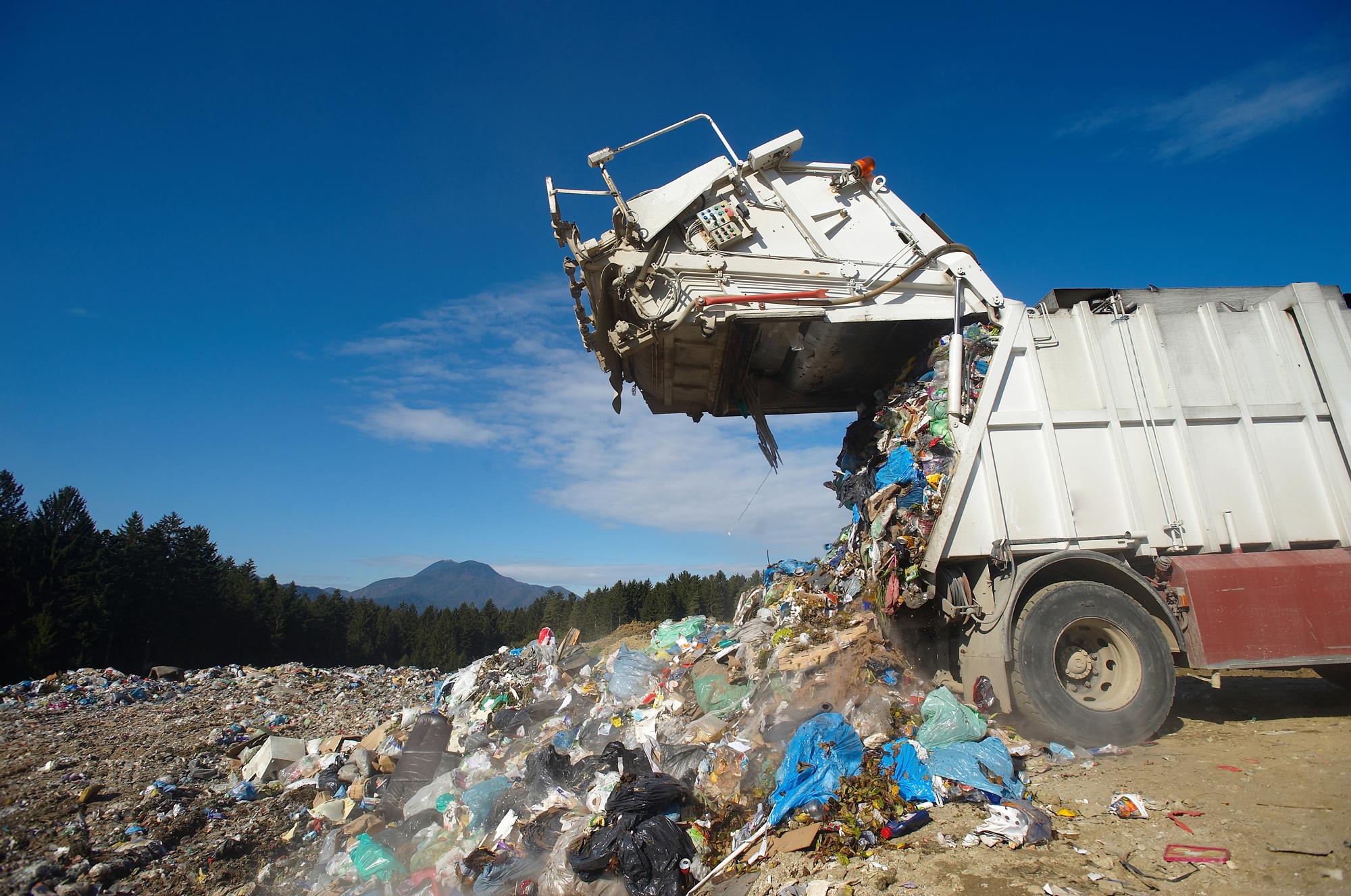 Garbage truck dumping waste into landfill 