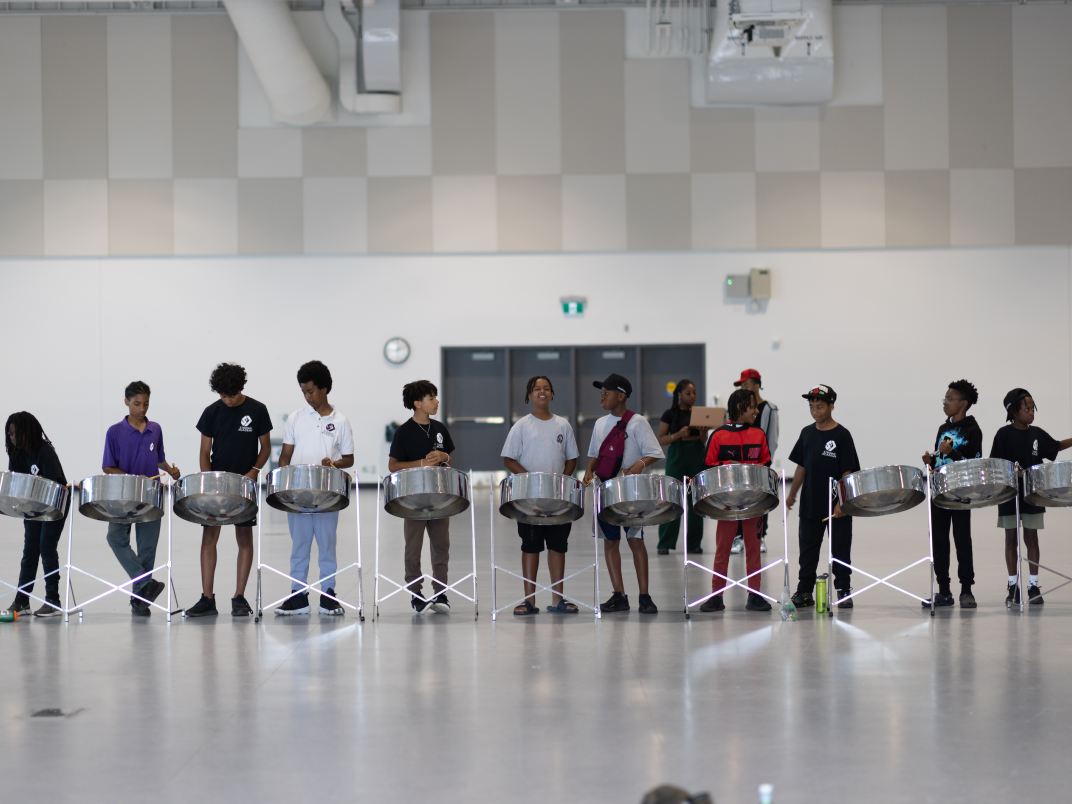 Row of boys playing steel pans in the UTSC Highland Hall event centre.