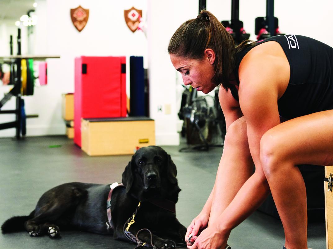 blind athlete victoria nolan seen tying her shoe in the gym with her seeing eye dog beside her