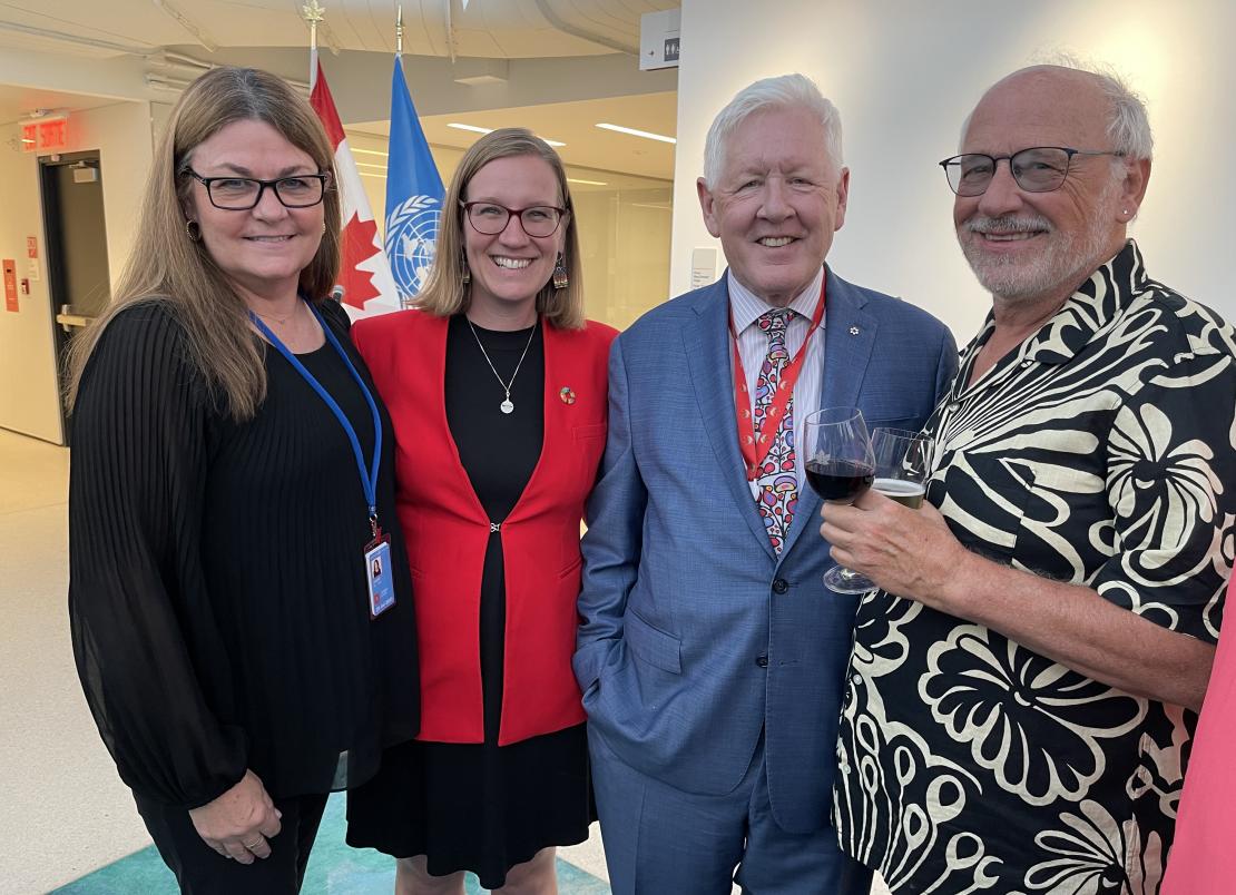 Irena Creed, Minister of Families, Children and Social Development of Canada and Head of the Canadian Delegation Karina Gould  And Bob Rae, Permanent Representative of Canada to the United Nations Bob Rae and Charles Trick in front of the Canadian and UN flags at UN headquarters. 