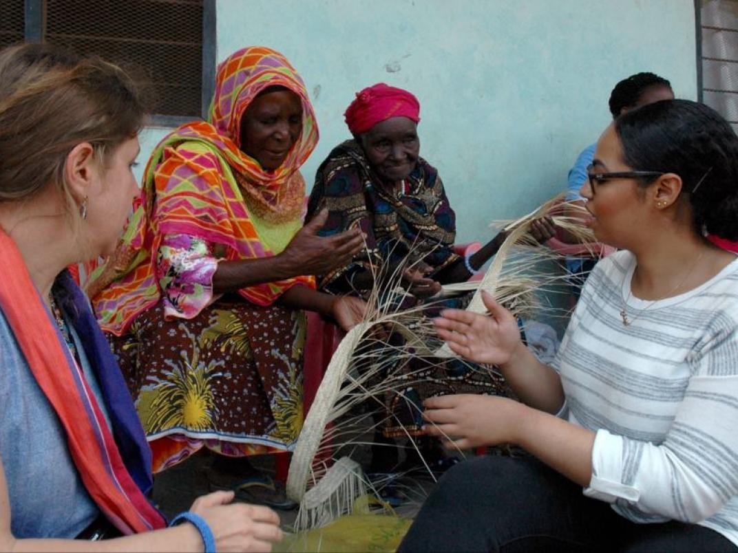 Reenas Mohamed (right) pictured with Masaai women during a visit to a cultural toursim enterprise. The women showed the students weaving techniques they use to make the different handmade products they sell.