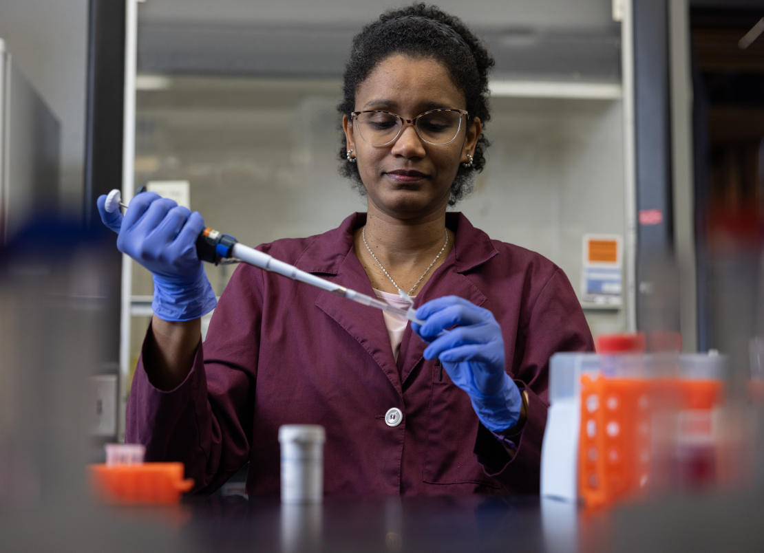 An image of Safia Omer using test tubes in a lab at U of T Scarborough