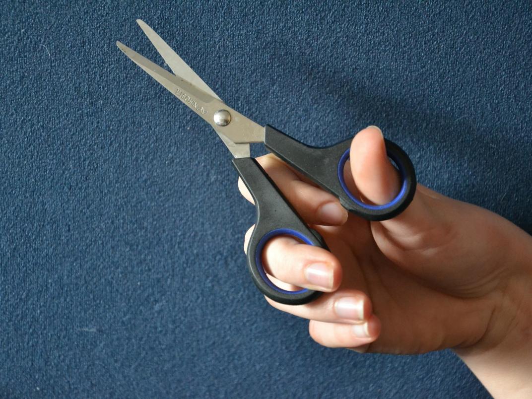 Hand holding a scissor