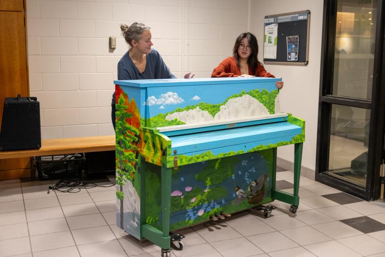 Lynn Tucker (left) and Connie Lin unveiling the piano