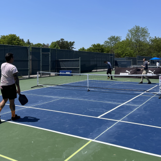 Four people playing pickleball on a court