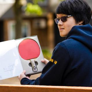 A photo of Julian Liu with his ping pong paddle