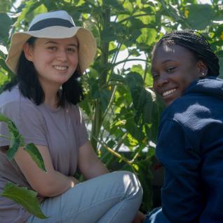 Shakhnoza Vafaeva and student Jeda McCall smile while working in the IC Rooftop Garden.