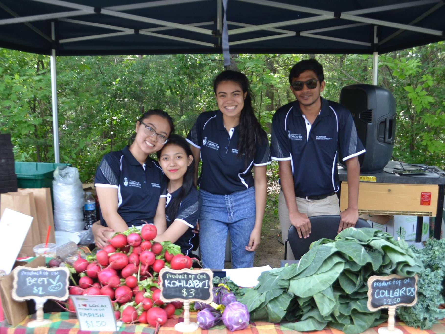 Image of produce on a table with four students standing behind the table