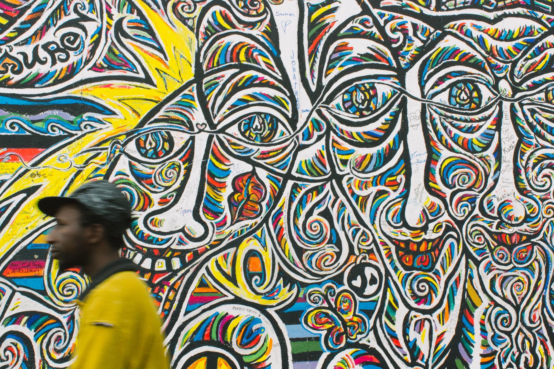 Man in front of mural 