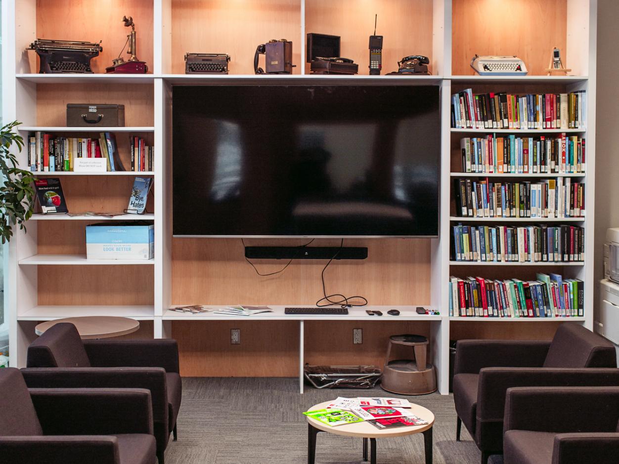 Library shelves with books, soft seating and table