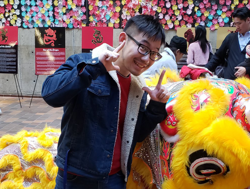 Student posing with a dragon for lunar new year